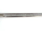 a close up of a knife on a white surface with a ruler
