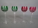 four wine glasses are lined up in a row on a table