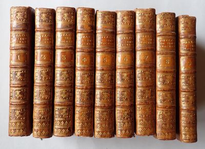 several old books are lined up on a white surface