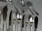 a lot of silver spoons and forks on the table