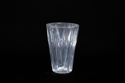 du verre transparent posé sur une surface noire, avec un fond noir
