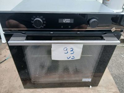 un four noir dont la porte est ouverte et sur lequel est accrochée une étiquette de prix
