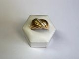 une bague en or posée sur une boîte blanche