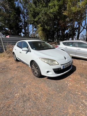 deux voitures garées sur un parking à côté d'une clôture et d'arbres