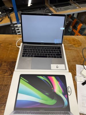 two laptops sitting on a table next to each other