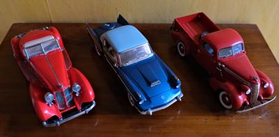 trois petites voitures posées les unes à côté des autres sur une table