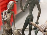 a statue of a man holding a baseball bat next to a figurine of a man holding a baseball bat