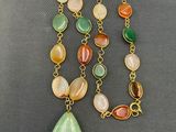 a close up of a necklace with a tear shaped pendant on it
