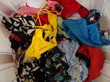 a basket full of clothes that is sitting on a bed