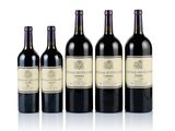 six bottles of wine are lined up in a row on a white surface