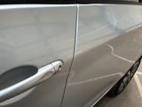 a silver car parked in a parking lot with its door open