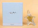 un gros plan d'un flacon de parfum à côté d'une boîte