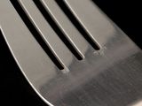 a close up of a fork on a black surface