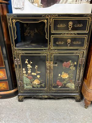 un meuble noir et doré orné de fleurs
