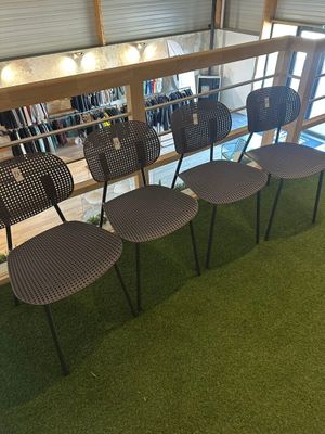 four chairs that are sitting on the grass in front of a window