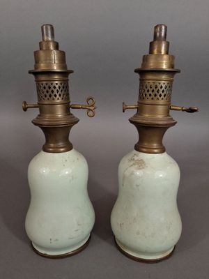 paire de lampes à huile anciennes en laiton et en céramique verte sur fond gris