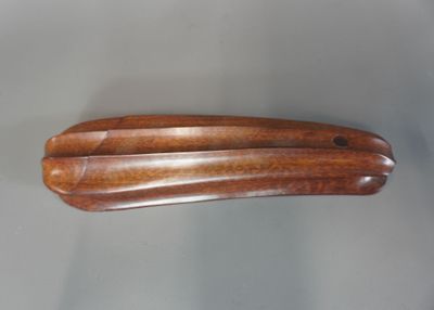 un objet en bois posé sur une table, sur fond blanc
