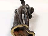 a bronze statue of a man holding a trumpet