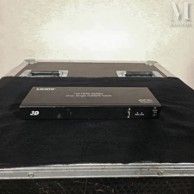 un boîtier noir sur lequel sont posées deux télécommandes
