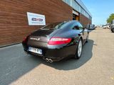 a black porsche parked in front of a building