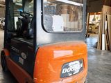 a small orange fork truck parked in a warehouse