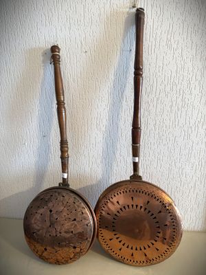 paire de poêles anciennes en cuivre avec des manches en bois