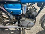 une moto bleue garée sur le bord de la route