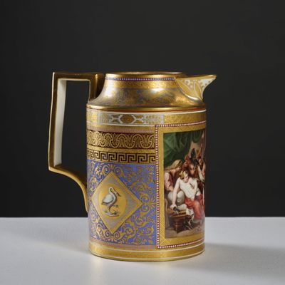 a gold and blue coffee pot with a painting on it