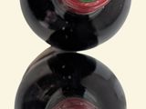 two bottles of wine sitting on top of each other