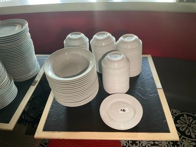 de nombreuses assiettes et tasses posées sur un plateau posé sur la table
