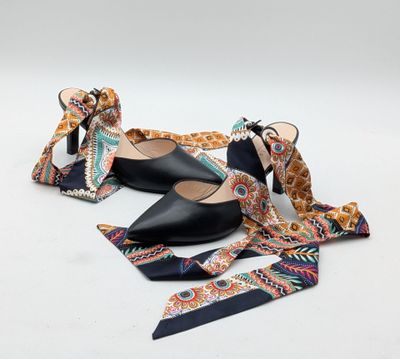 une paire de chaussures noires avec un nœud autour