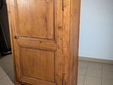 a tall wooden cabinet in the corner of a room