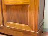 a wooden cabinet with a glass door on top of it