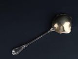 a silver spoon with a spoon handle on a black surface