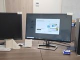 three computer monitors on a desk with a keyboard and mouse