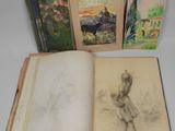 three books with drawings on them sitting on top of a table