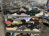 a cart full of clothes that is sitting in a warehouse