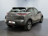the rear end of a grey car in a showroom
