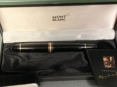 un stylo noir dans une boîte contenant un bloc-notes et un livre