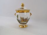 a white and gold vase with a picture of a castle on it