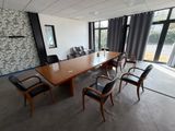 une grande salle de réunion avec une longue table et des chaises noires