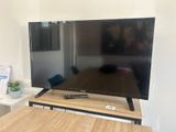a flat screen tv sitting on top of a wooden table