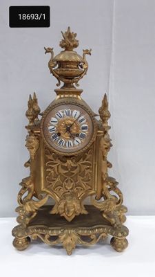 a gold clock sitting on top of a white table