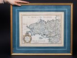 a person holding up a framed map of the country of france