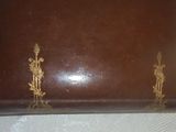 un coffret marron orné de motifs dorés, posé sur une table