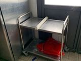 un chariot argenté sur lequel est posé un sac rouge, dans une cuisine