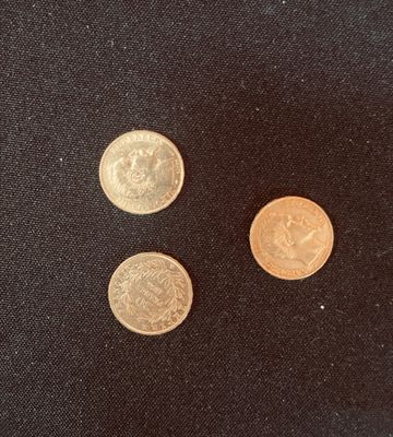 three different types of coins on a black surface