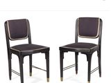 pair of black chairs with gold trimmings on the back