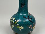 a blue vase with birds and flowers painted on it