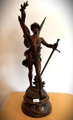 une statue représentant un homme tenant une épée, posée sur une table